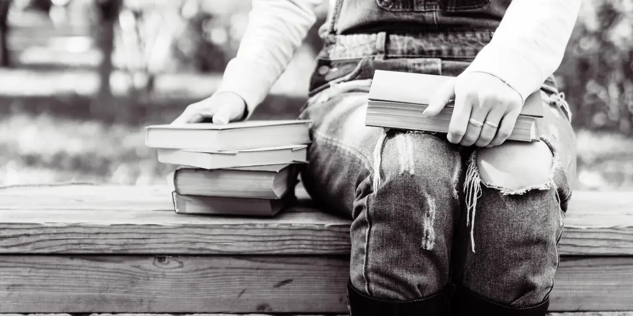 Persona sentada con varios libros en francés fáciles de leer, listos para una tarde de lectura.