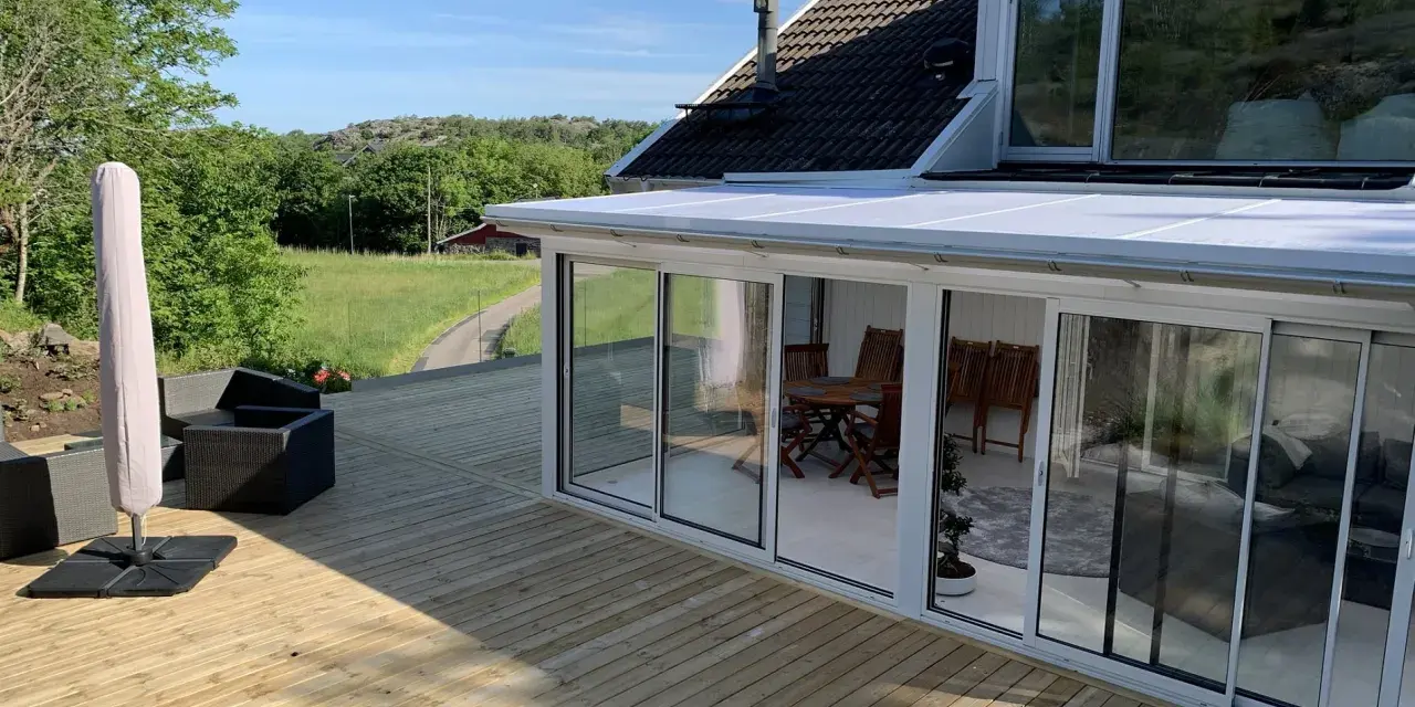 Ny slipad altan med glasveranda och utemöbler. Perfekt för att njuta av sommaren.