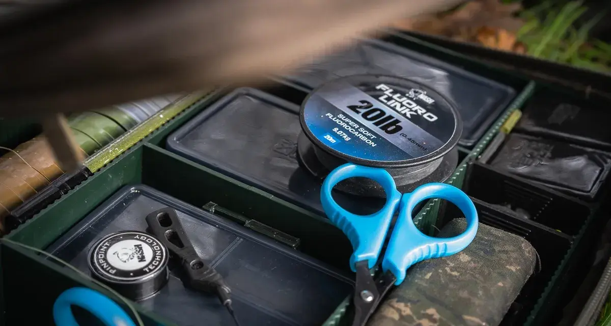Alles für die beste Karpfenmontage: Fluorocarbon-Schnur, Schere und Zubehör in einer Tacklebox.