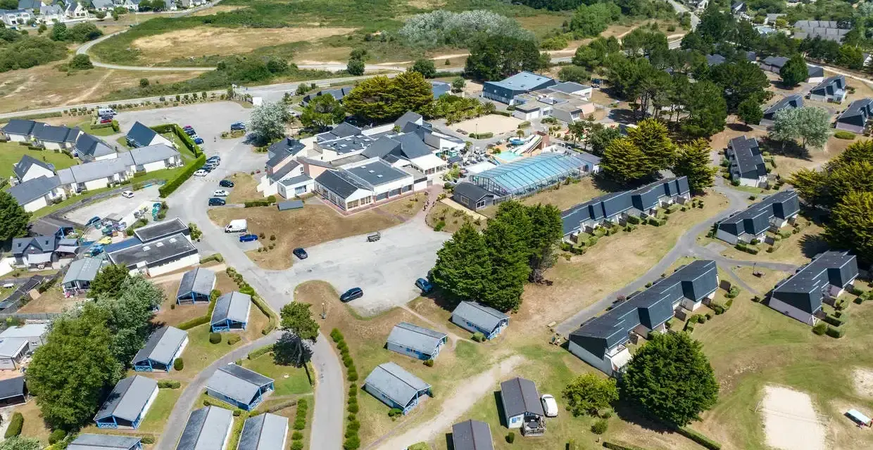 Vue aérienne d'une zone vacances Bretagne avec des maisons, une piscine et des espaces verts.