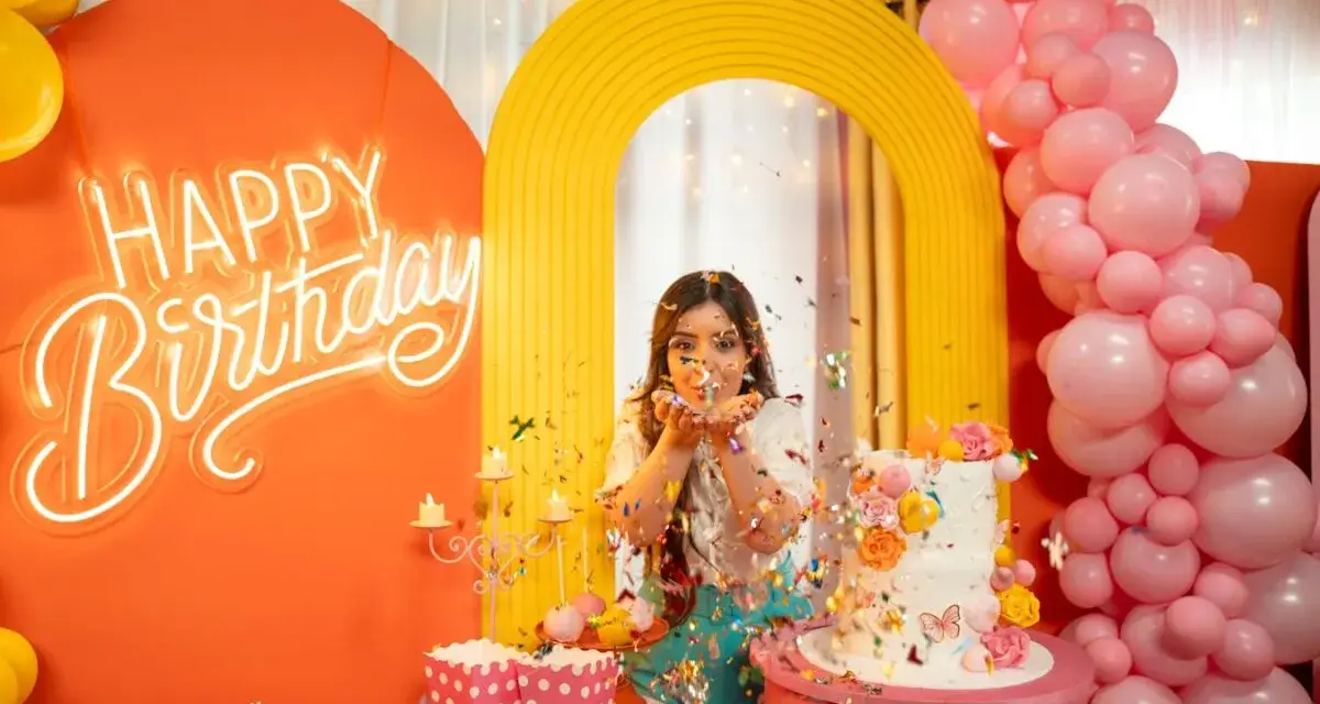 Kolorowe przyjęcie urodzinowe z neonowym napisem "Happy Birthday", tortem i konfetti. Fajne pomysły na urodziny dla nastolatków!