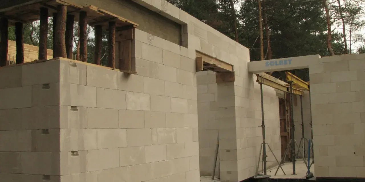 Budowa domu z bloczków betonowych. Widoczny maksymalny otwór bez nadproża, przygotowany do montażu okna lub drzwi.