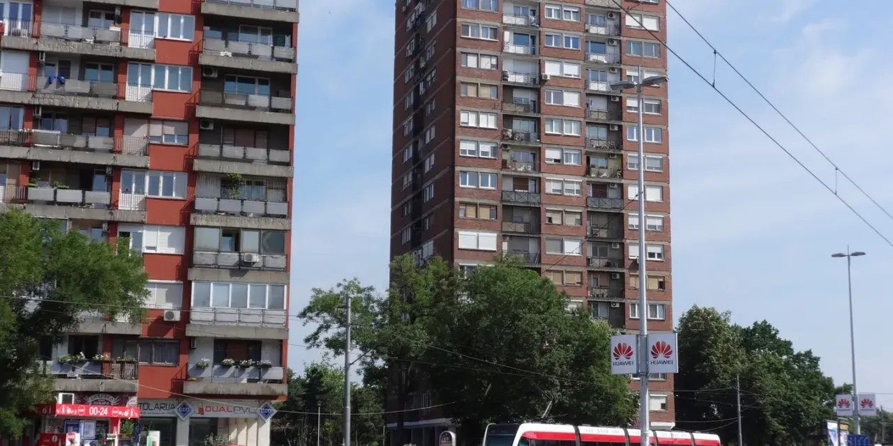 Wielopiętrowe budynki mieszkalne i nowoczesny tramwaj na ulicy. Czy w Belgradzie jest bezpiecznie? Wygląda na spokojne miasto.