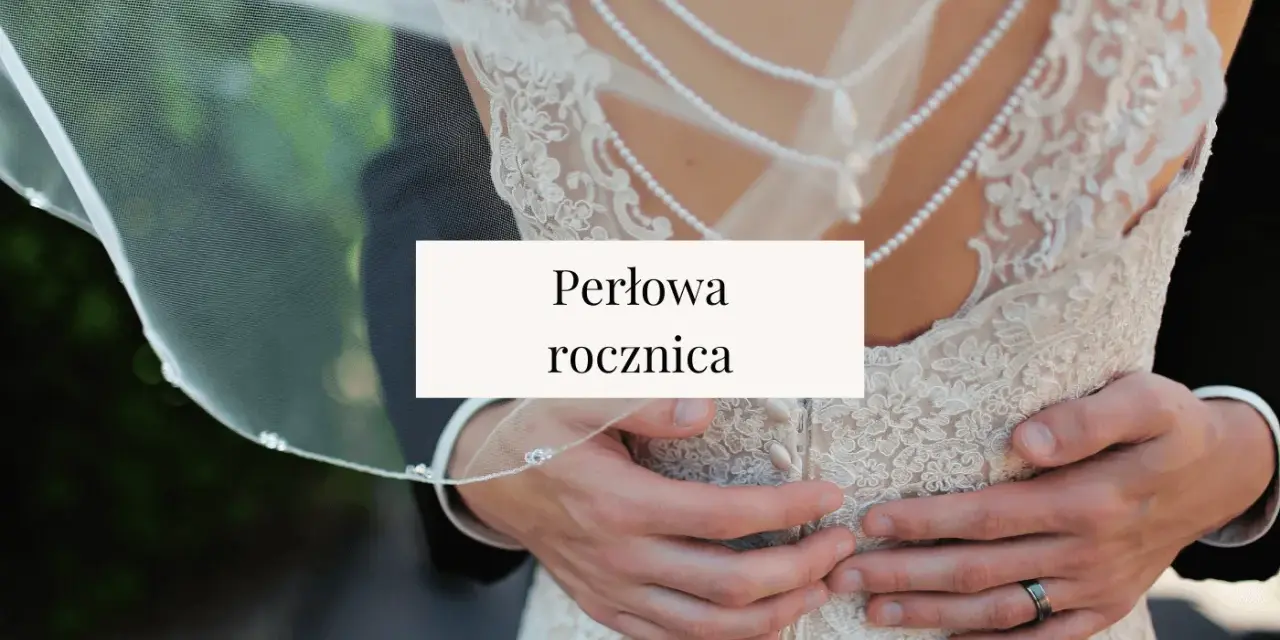 Perłowa rocznica ślubu. Dłonie obejmujące suknię ślubną z koronki i pereł.