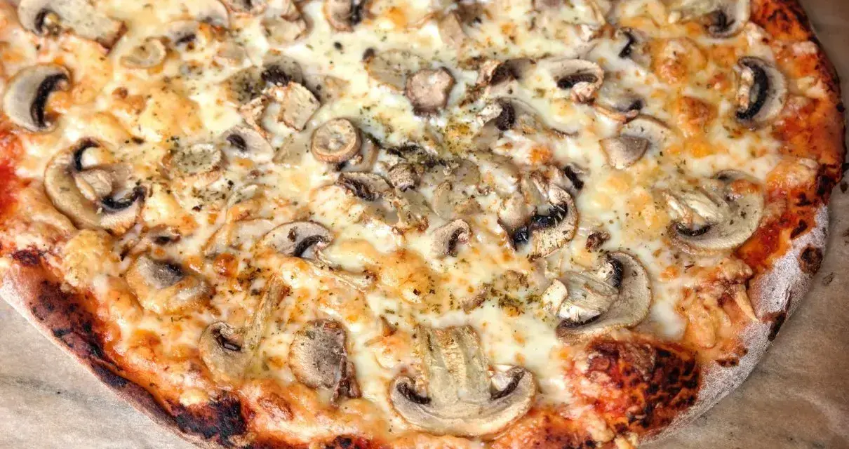 Pyszna pizza z pieczarkami i ciągnącym serem. Idealna na wspólne spotkanie, bo ile piec pizze, tyle radości!