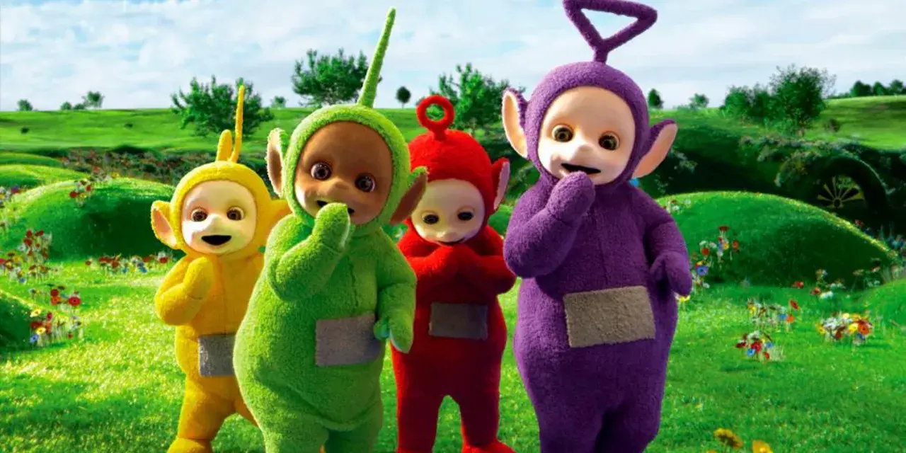 Teletubisie imiona: Tinky Winky, Dipsy, Laa-Laa i Po stoją na zielonej łące pełnej kwiatów.