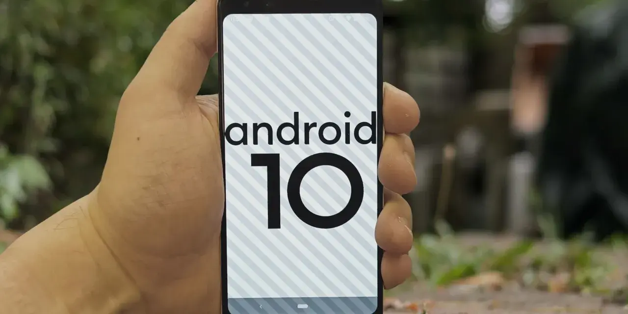 Dłoń trzyma smartfon z logo android 10 na ekranie.