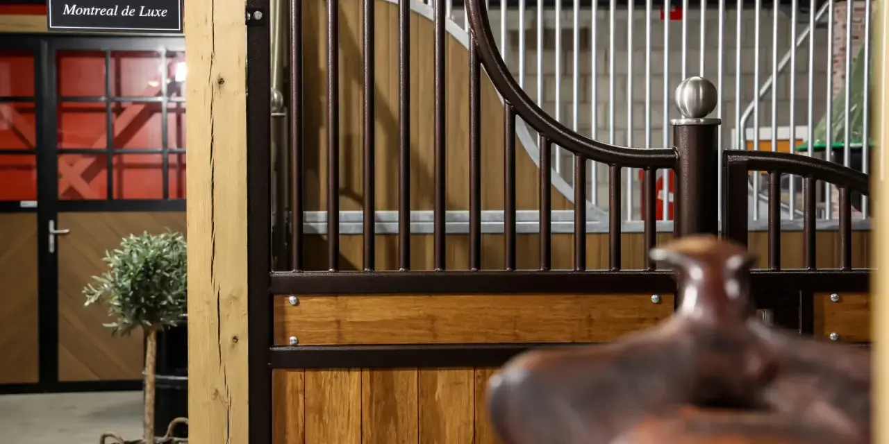 Une écurie de luxe avec des portes en bois, des barreaux en métal et un signe "Montreal de Luxe".