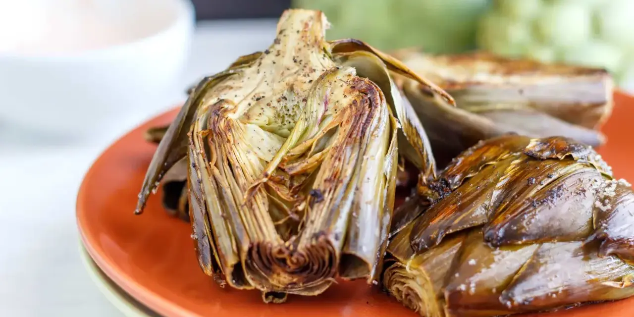 Alcachofas al horno, doradas y tiernas, listas para disfrutar. Un plato sencillo y delicioso.