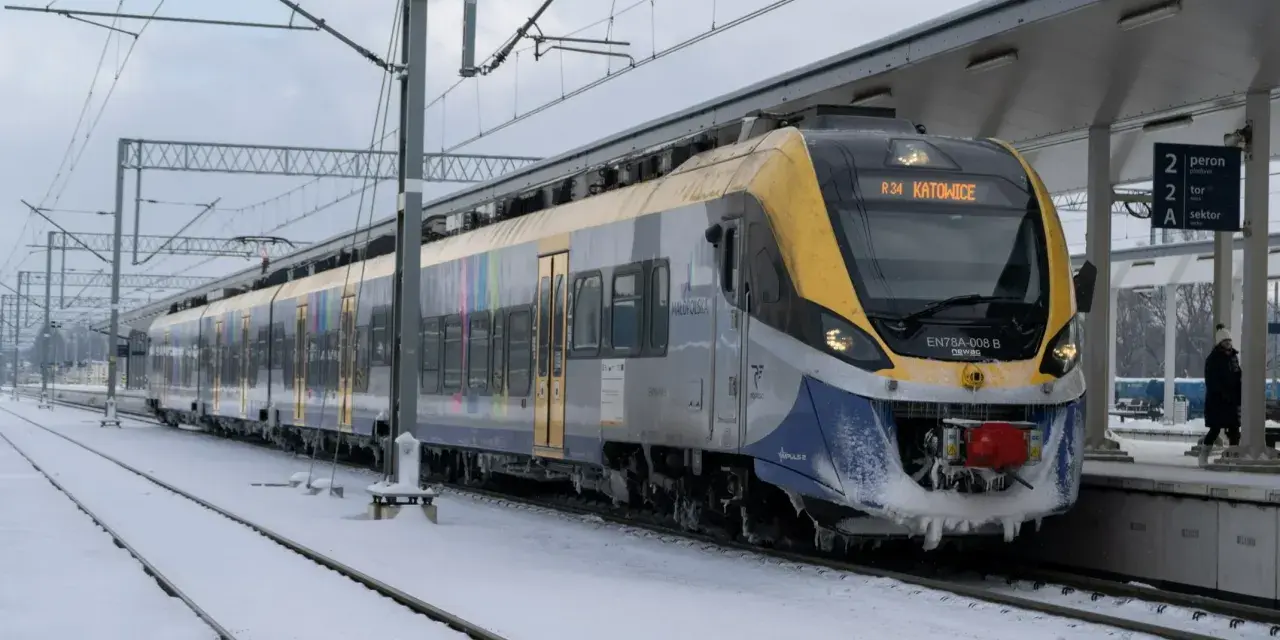 Pociąg EN78A-008 B relacji R34 Katowice stoi na zaśnieżonym peronie. Podróżuj taniej z bliskimi, wybierając kolej.