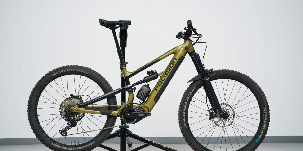 A gold Polygon mullet bike with a dropper post, full suspension, and knobby tires, ready for any trail.
