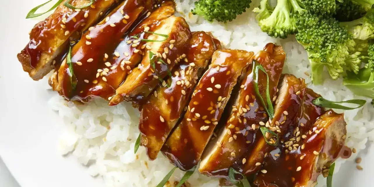Pyszny kurczak w marynacie teriyaki, podany z ryżem i brokułami. Posypany sezamem i szczypiorkiem.