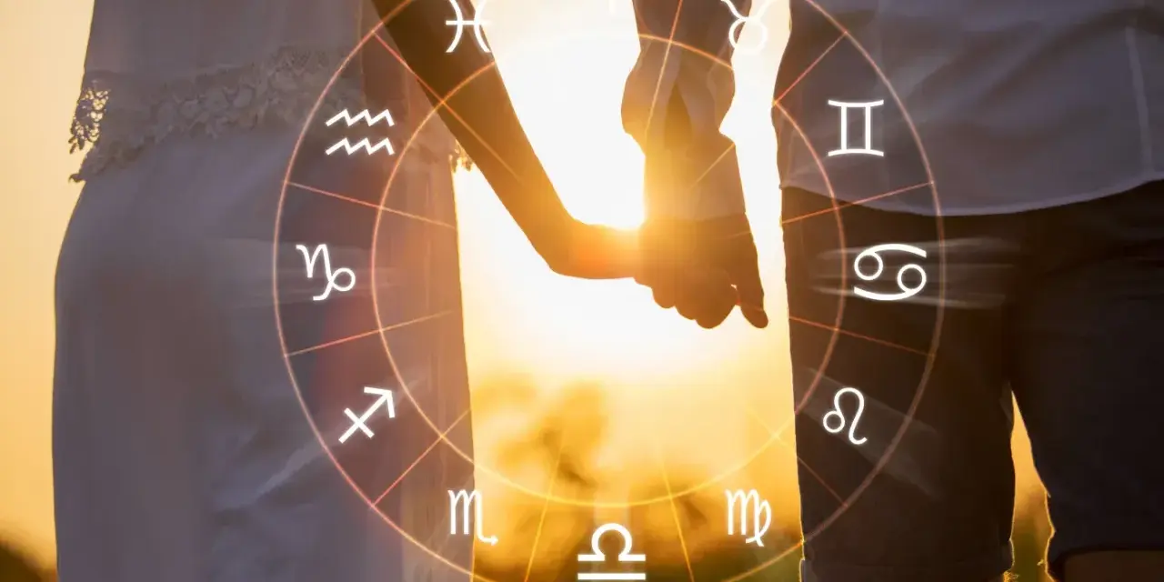 Para, trzymająca się za ręce, na tle zachodzącego słońca, z widocznym kołem zodiaku, gdzie widnieją symbole byka i koziorożca.