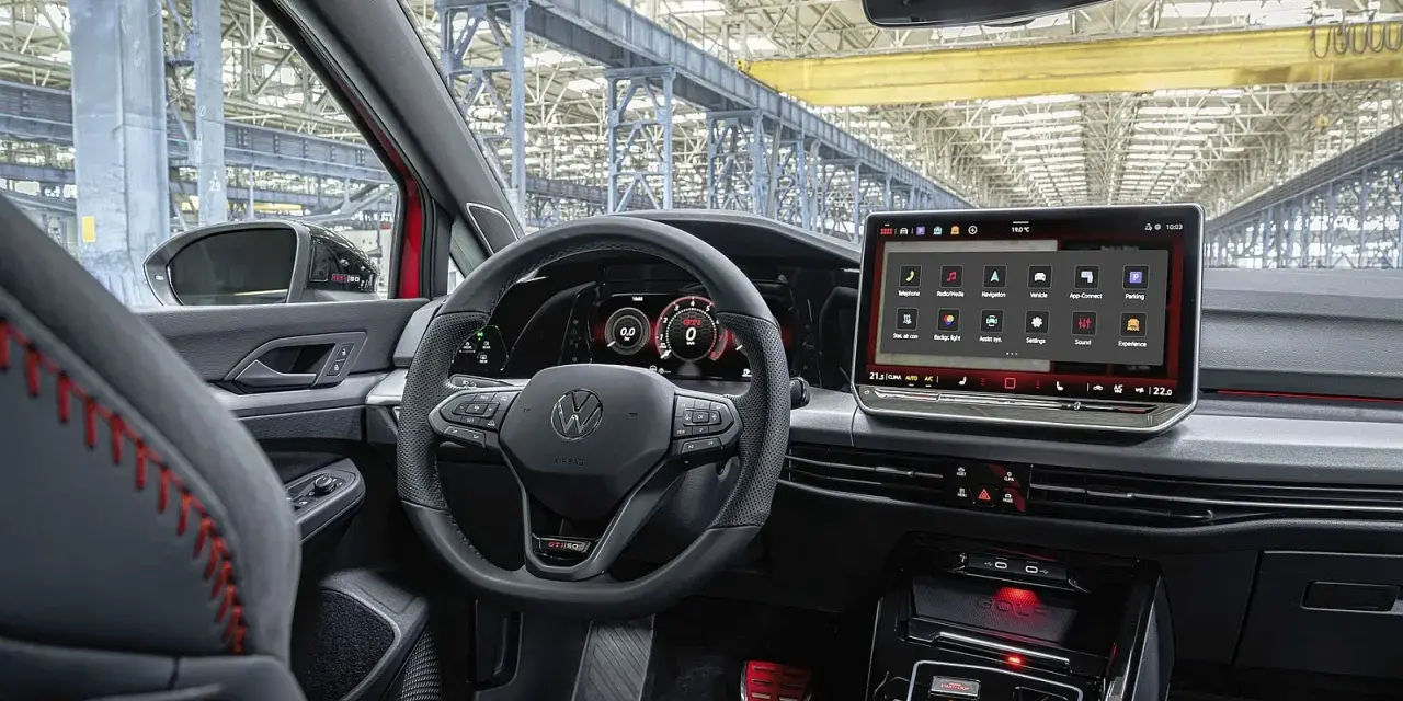 Wnętrze samochodu Volkswagen Golf z dużym ekranem dotykowym i cyfrowymi zegarami.