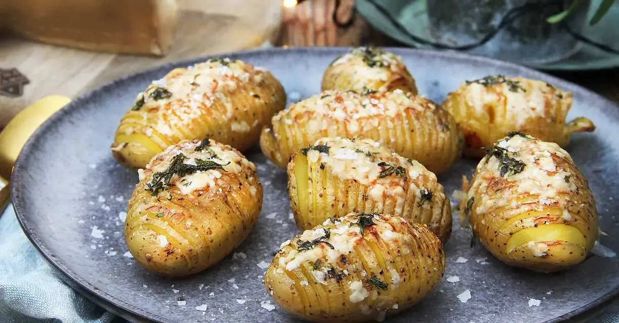 Hasselbackspotatis recept: gyllene, krispiga potatisar med ost och örter, redo att avnjutas.