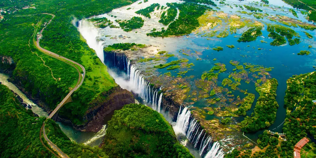 Wodospad Wiktorii, jedna z największych atrakcji Zimbabwe, z lotu ptaka. Potężny nurt rzeki Zambezi spada kaskadami w dół, tworząc mgłę i tęczę.