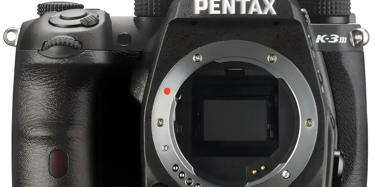 Czarny aparat Pentax K-30 z widocznym bagnetem obiektywu i oznaczeniem "SR". Gotowy do uchwycenia wyjątkowych chwil.
