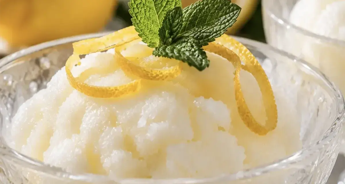 Sorbetto al limone senza albume, fresco e profumato, guarnito con scorzette di limone e foglioline di menta.