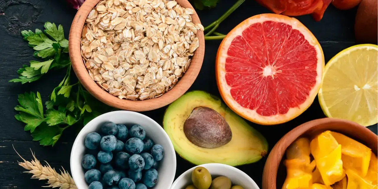 Assortiment de fruits et légumes : flocons d'avoine, myrtilles, avocat, pamplemousse, citron, olives, mangue. Attention aux aliments mauvais pour la flore intestinale.