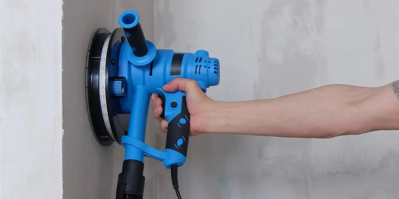 Utensile blu per levigare il muro, ideale per capire come togliere la vernice dal muro.