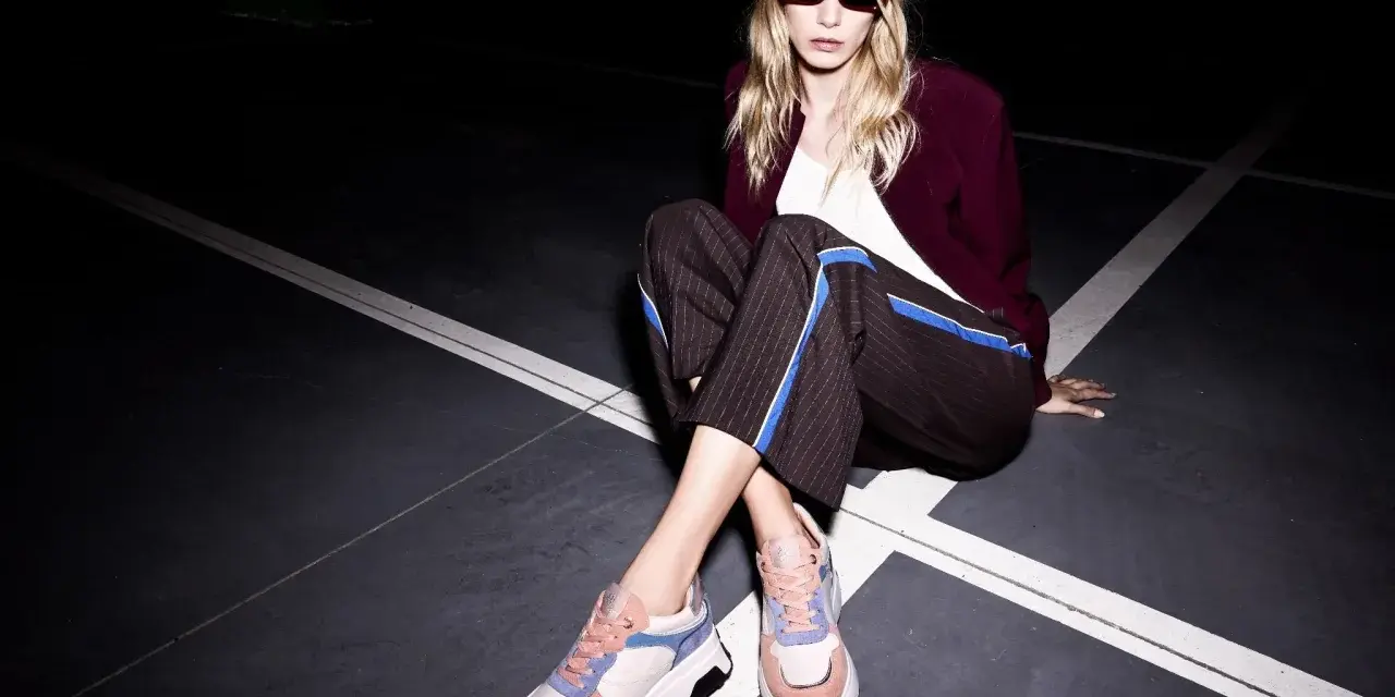 Moda audace: vestiti eleganti con scarpe da ginnastica colorate, per un look urbano e chic.
