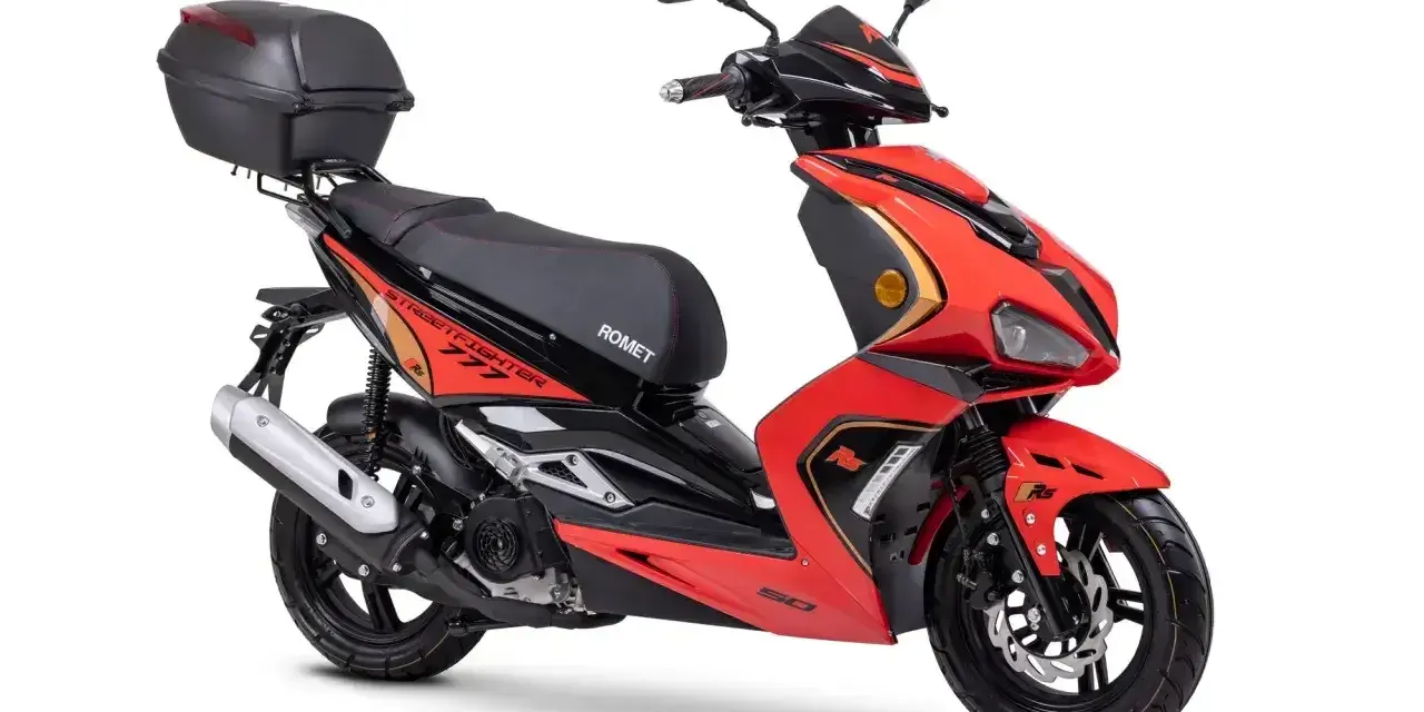 Czerwony skuter Rometa z kufrem. Zastanawiasz się, czy można jeździć motorowerem na dowód? Ten model jest idealny na polskie drogi.