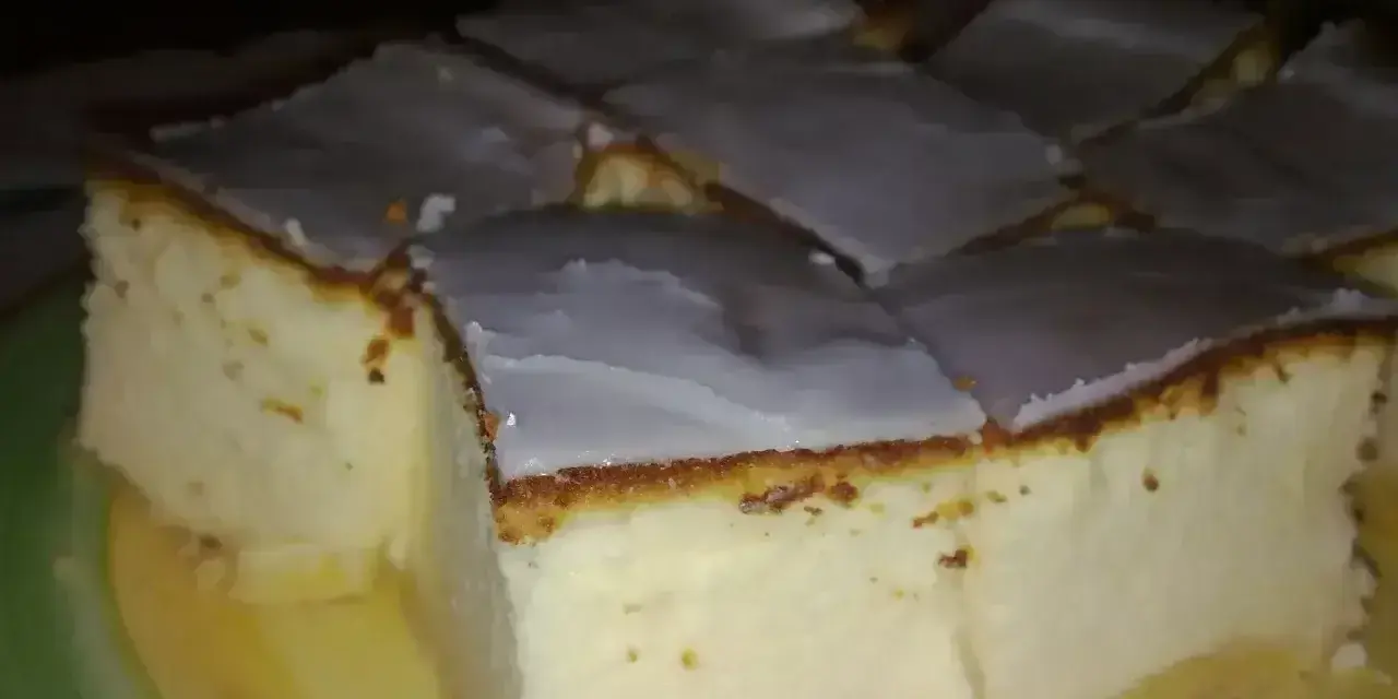Pokrojony na kwadraty sernik tradycyjny z lukrem, idealny na prosty przepis.