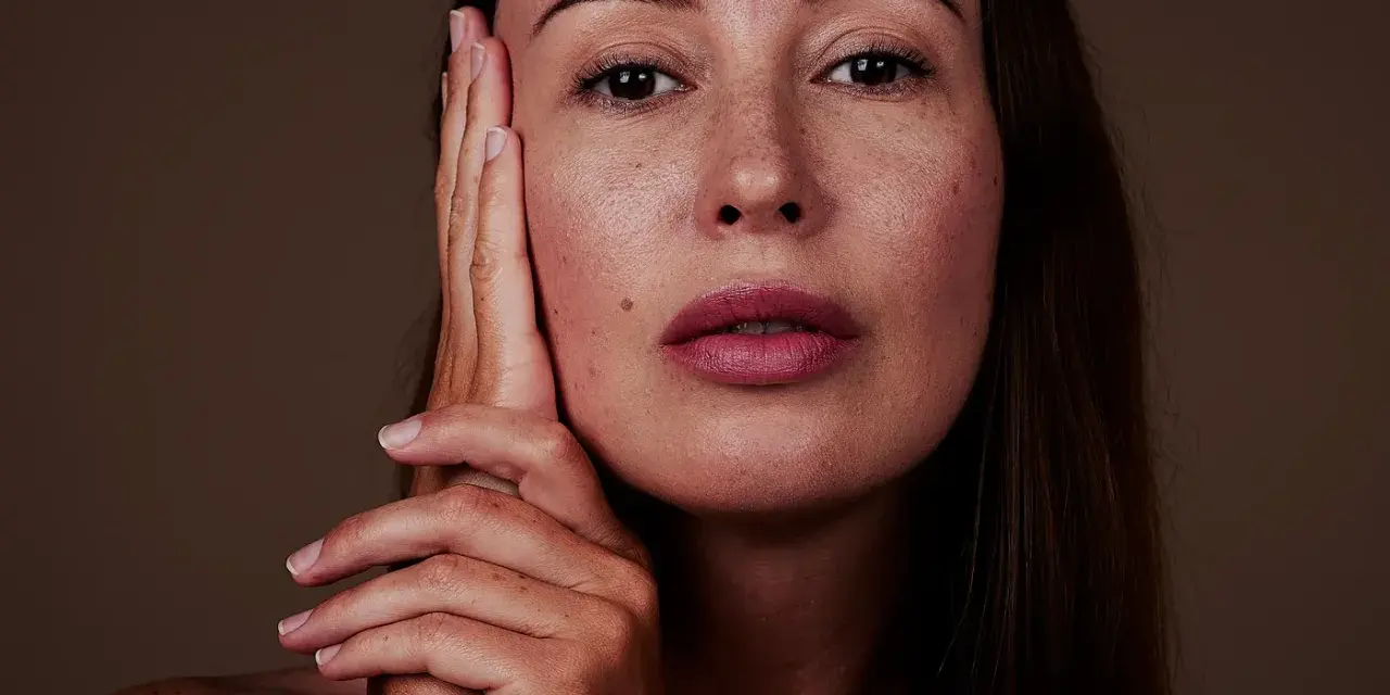 Nahaufnahme einer Frau mit Sommersprossen. Die sanfte glycolic acid wirkung lässt ihre Haut strahlen.