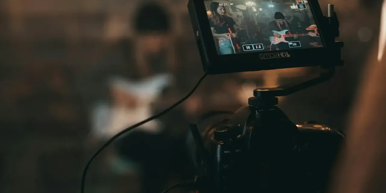 Kamerafilmung einer Band für die Sync-Lizenzierung. Auf dem Monitor ist eine Frau mit Gitarre zu sehen.