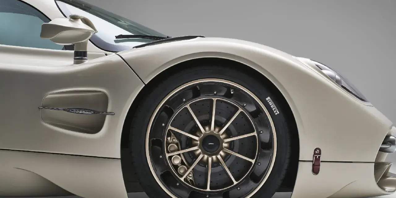 Dettaglio di un'auto sportiva color champagne, con focus sulla ruota e sul pneumatico. La corretta pressione pneumatici auto è fondamentale per prestazioni ottimali.