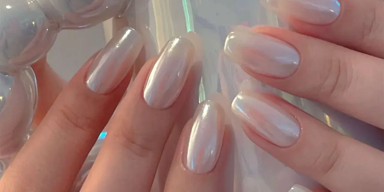 Mani eleganti con unghie a specchio perlate, che riflettono la luce con un effetto iridescente e sofisticato.