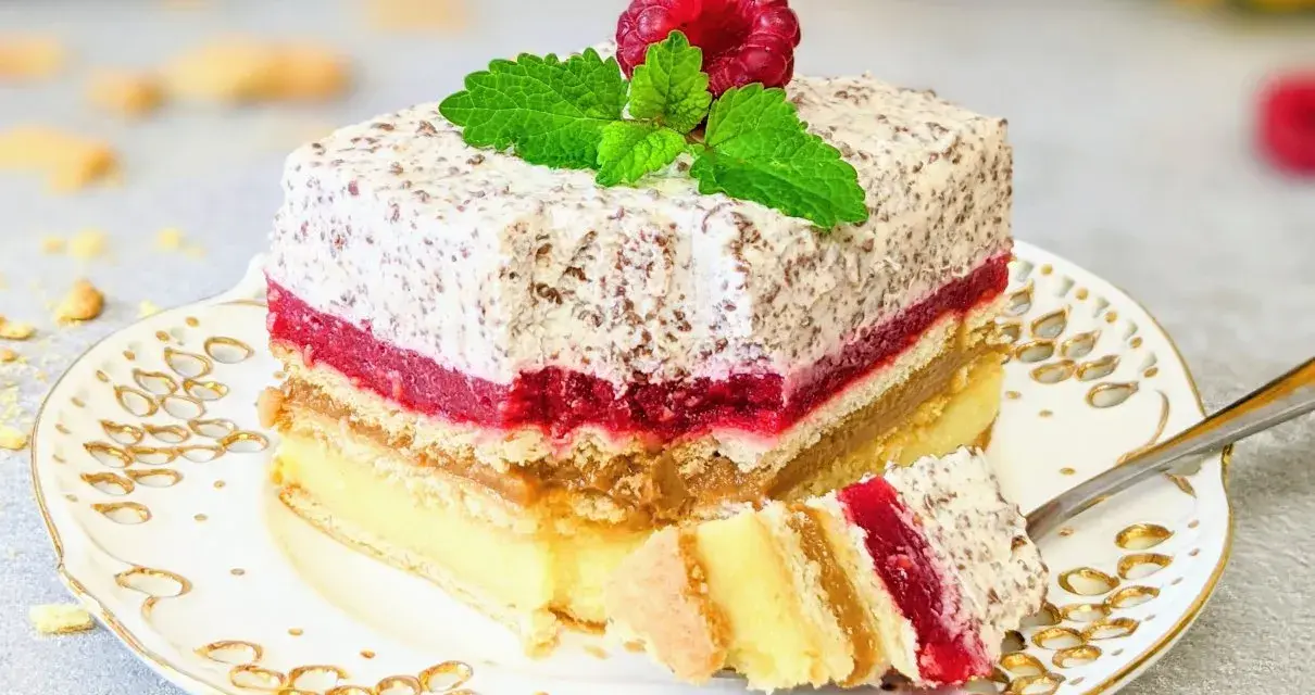 Tanie ciasto bez pieczenia z herbatnikami, przełożone kremem, malinową galaretką i karmelem. Udekorowane maliną i miętą.