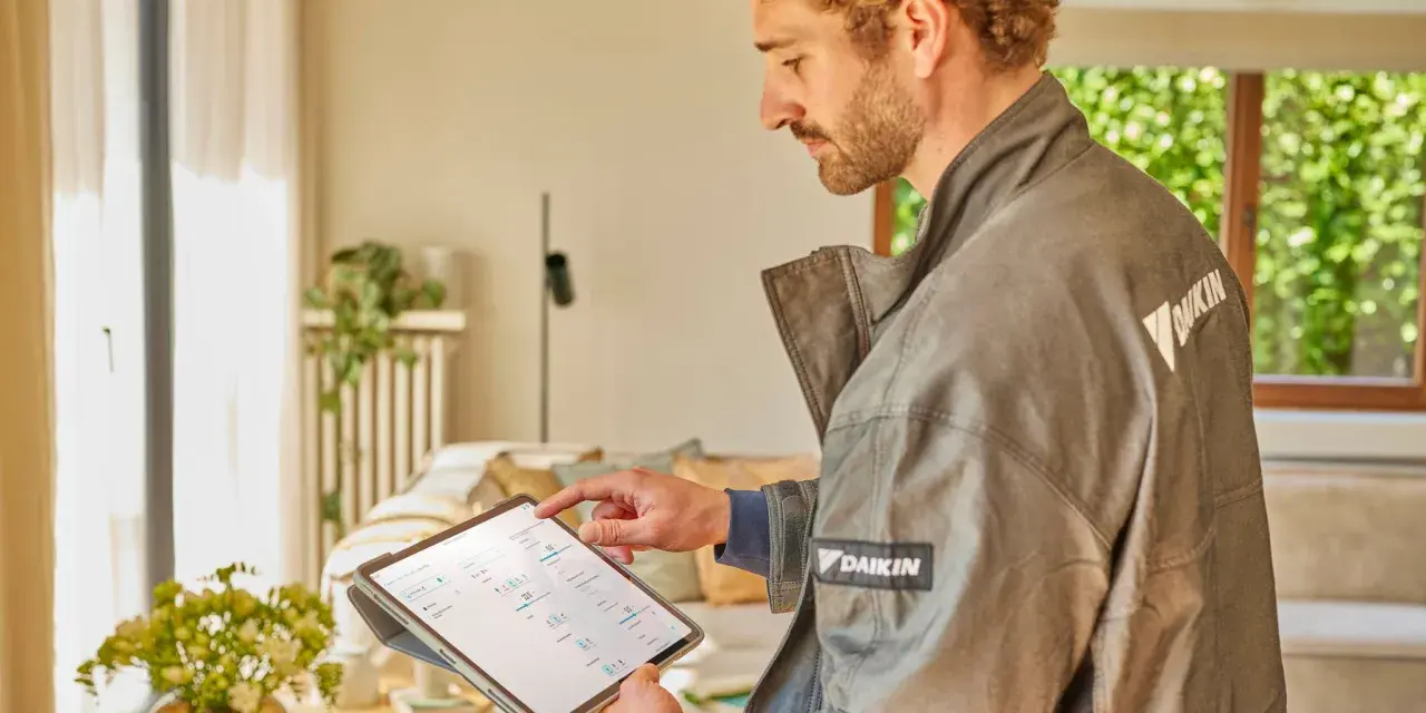 Técnico revisa datos en tablet para el mantenimiento de bomba de calor.