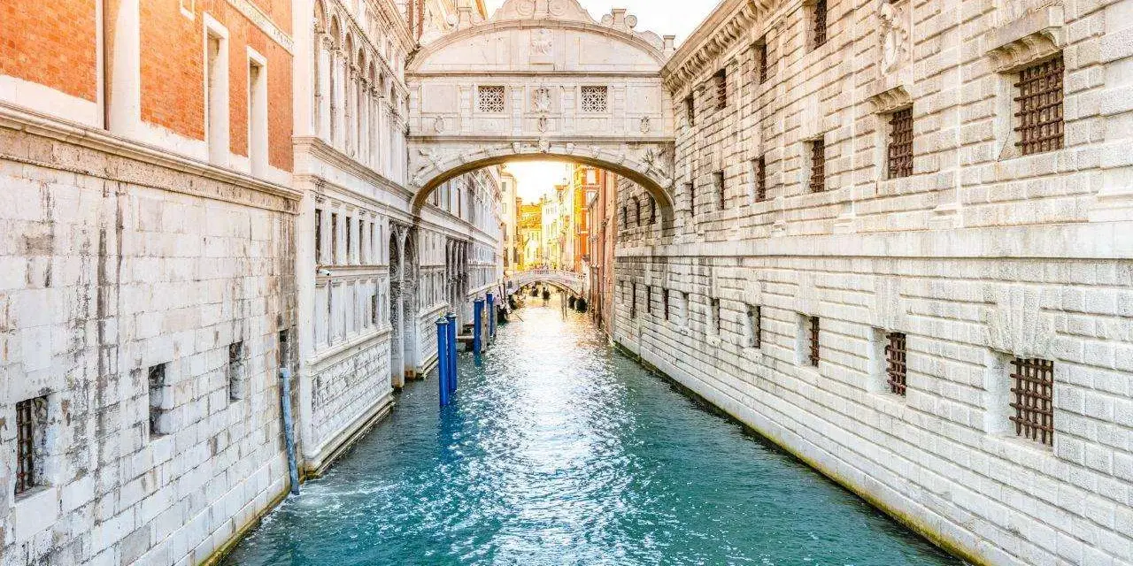 Il Ponte dei Sospiri a Venezia, con la sua leggenda di condanne e addii, si staglia maestoso sul canale azzurro.