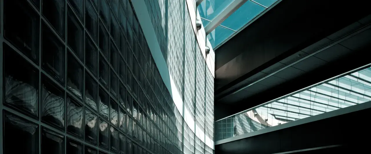 Mur extérieur en pose brique de verre, reflétant la lumière et créant des jeux d'ombres sur la façade moderne.