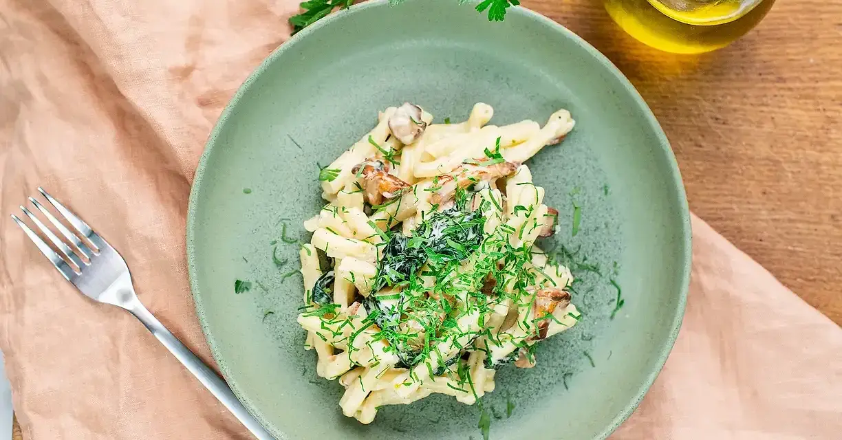 Krämig svamp pasta med färska örter på en grön tallrik, redo att avnjutas.