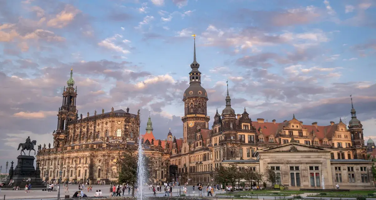 Zamek w Dreźnie z fontanną i pomnikiem konnym na placu. Architektura zachwyca o zachodzie słońca.