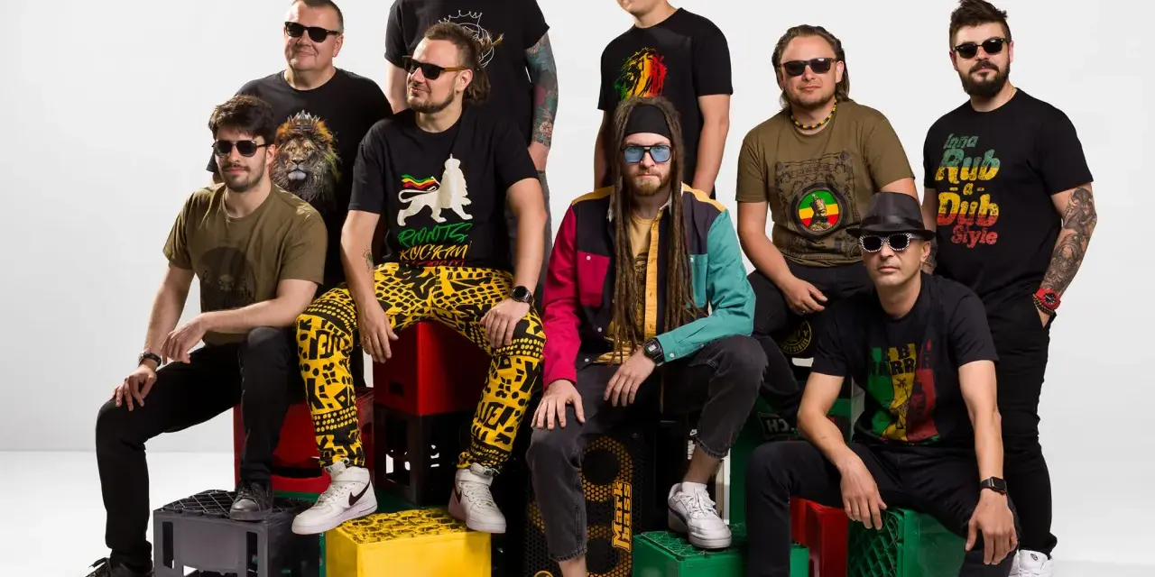 Grupa mężczyzn w koszulkach z motywami nawiązującymi do rastafarianizmu. Jeden z nich ma dredy i kolorową kurtkę, co może kojarzyć się z tym, czym jest rastafarianizm.