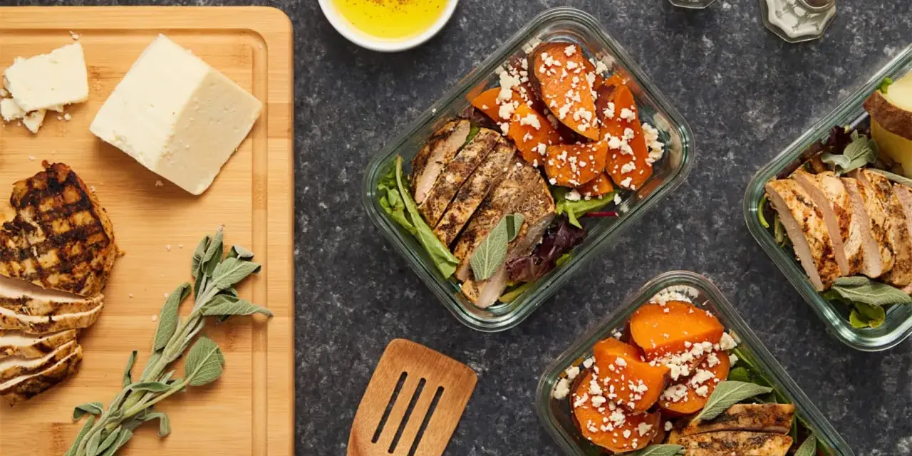 Repas préparés pour manger healthy : poulet grillé, patates douces, fromage et salade.