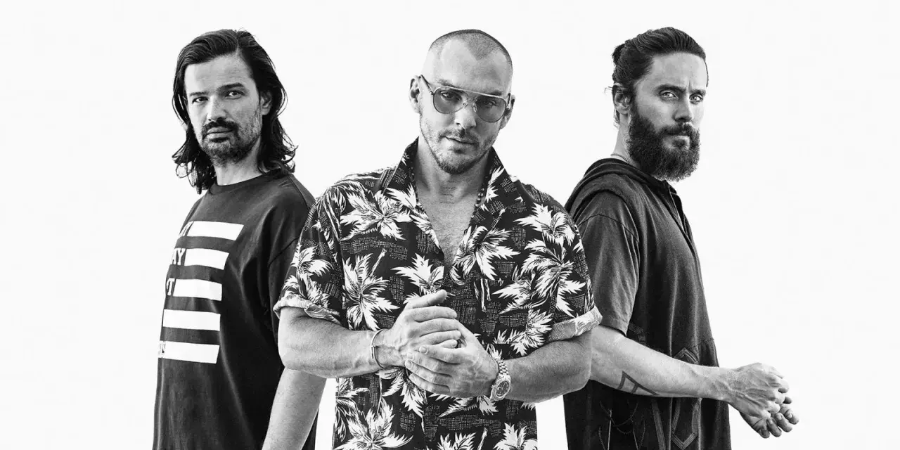 Les membres de Thirty Seconds to Mars posent ensemble, un regard intense sur le visage de Jared Leto.