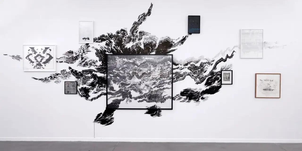 Œuvres d'Abdelkader Benchamma : une explosion d'encre noire sur mur blanc, encadrée par des dessins et peintures.