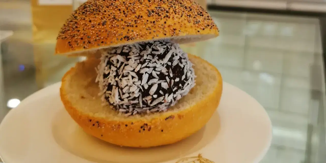 En bulle med bulle: en chokladboll med kokosflingor inuti en delad bulle med vallmofrön.