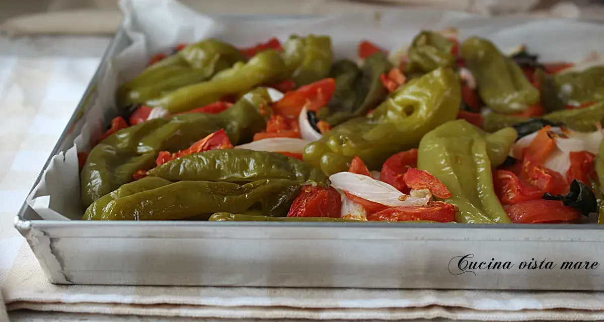 Friggitelli al forno con pomodori e cipolla, pronti per essere gustati.