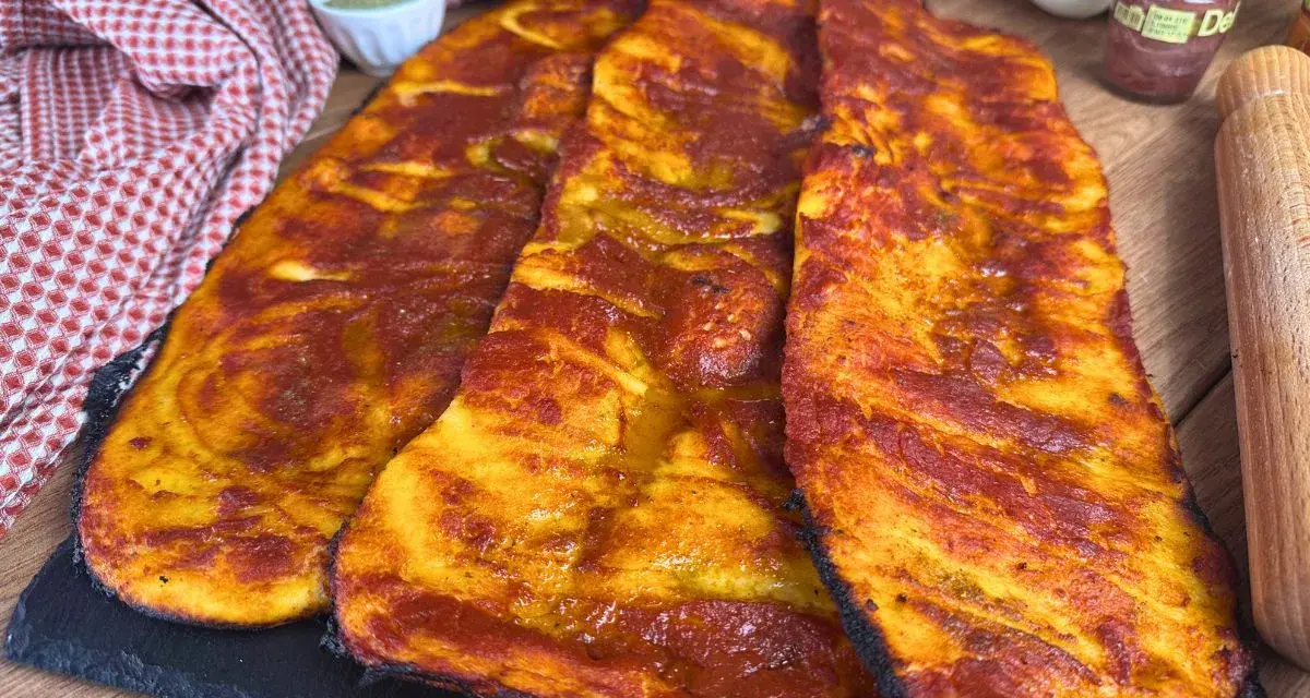 Lingue di pizza sottili e croccanti, condite con salsa rossa e dorate al forno.