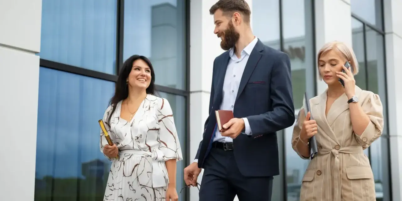 Mujeres con estilo para una conferencia: una con vestido estampado y clutch dorado, otra con traje de lino a rayas y hablando por teléfono.