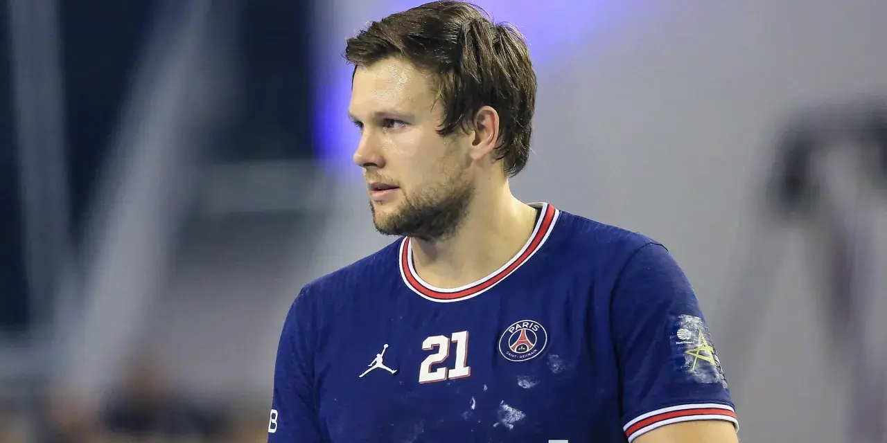 Piłkarz ręczny PSG z numerem 21 na koszulce, skupiony na grze.
