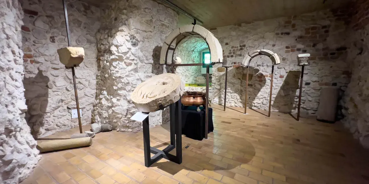 Wnętrze klasztoru w Tyńcu. Kamienne ściany, łuki i artefakty tworzą atmosferę historii.