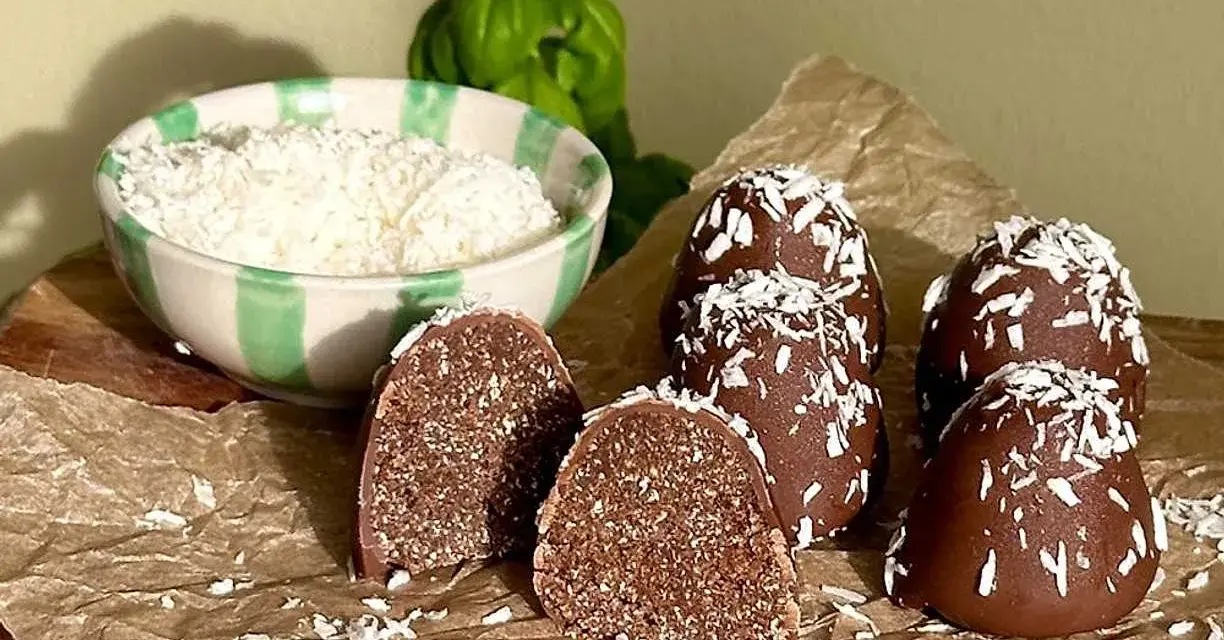 Chokladbollar recept: Mörka, kokosdränkta godsaker med en skål riven kokos i bakgrunden. Perfekt för fikat!
