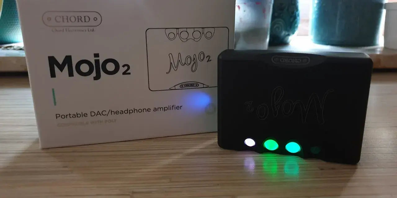 Zestaw Chord Mojo 2: pudełko i czarny wzmacniacz z podświetlanymi przyciskami.