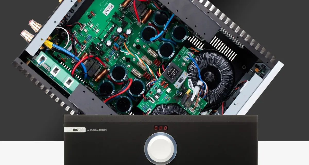 Wnętrze wzmacniacza Musical Fidelity M6 500i z widocznym transformatorem i płytką drukowaną.